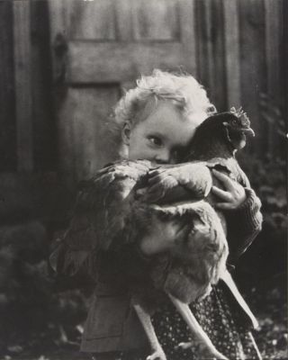 Girl (Nell Dorr) hugging chicken